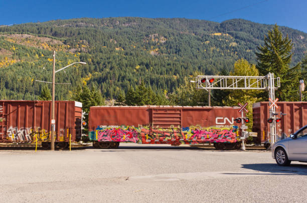 Traffic waiting at a railway crossing as train passes near North Bend, BC, Canada.