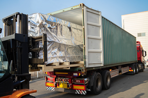 loading cargo into a container on a big trailer truck with a folk lift