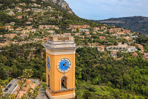 View onto an old church tower and villas perched up on the hillside in the Alpes by Eze village on the French Riviera, South of France