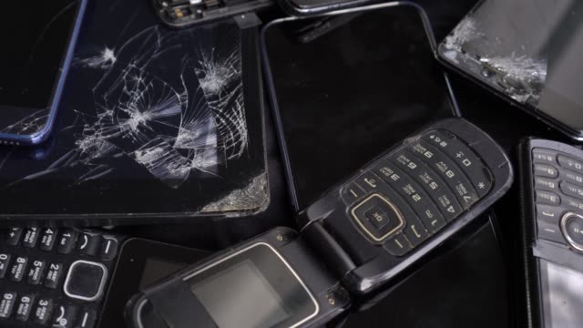 Obsolete old cell phones and broken smartphones with cracked screen