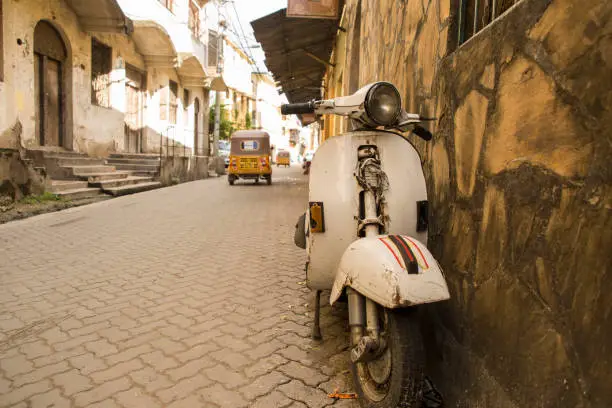 A vintage scooter motorcycle is parked on the streets of Old town Mombasa county, Kenya.