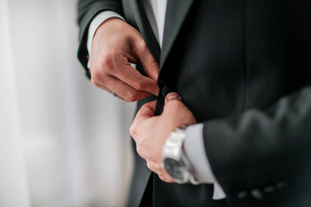 istock close up. groom buttoning his jacket. holidays and events 1206578290