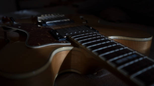 istock Vintage archtop guitar in natural maple close-up back light high angle view 1206579221