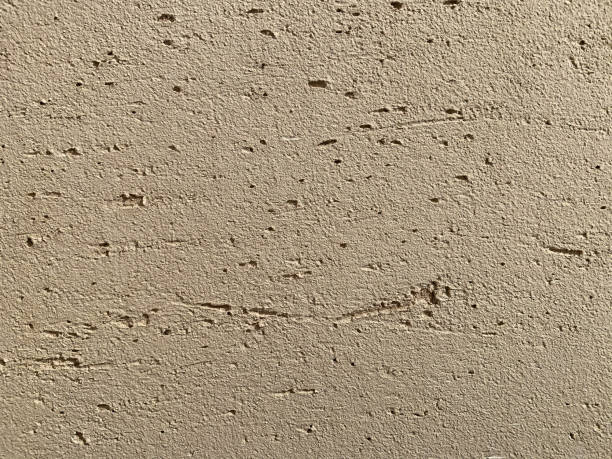 istock Beige decorative stucco on uneven wall surface painted during apartment renovation. Repair and decoration of premises. Background texture pattern copy space for text 1206580880