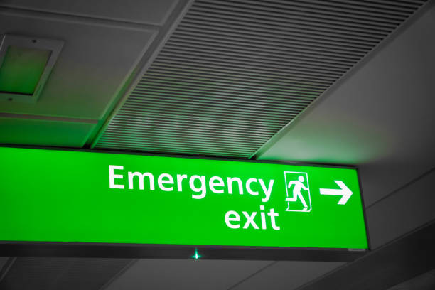 istock Emergency exit sign glowing green  in airport- for safety 1206581198
