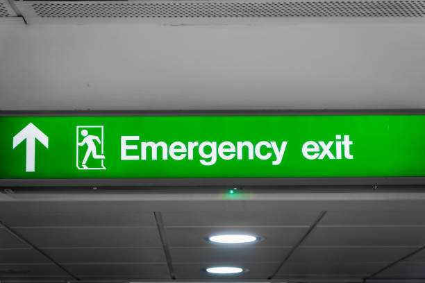 istock Emergency exit sign glowing green  in airport- for safety 1206581862