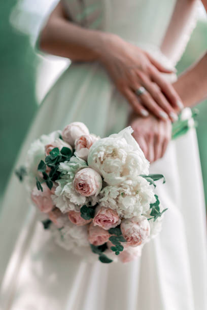 istock close up. the bride holds the wedding bouquet behind her back. 1206583059