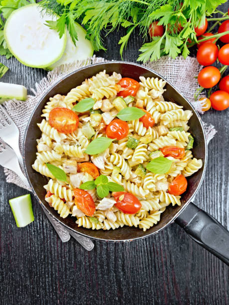 istock Fusilli with chicken and tomatoes in pan on black board top 1206585327