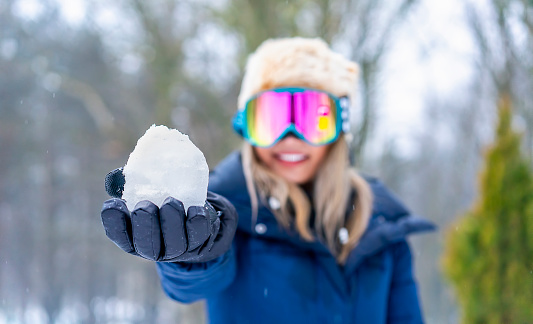 Female Snowboarder with ski goggles enjoying snowy weather