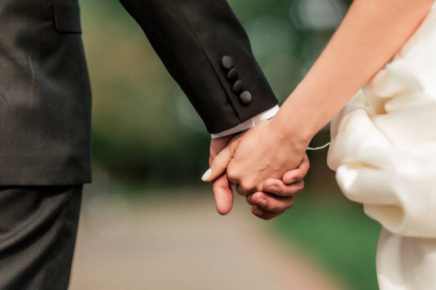 istock close up. bride and groom walking together. 1206589122