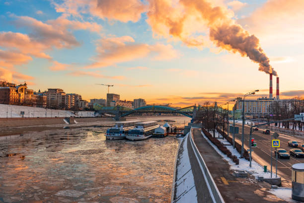 ciel dramatique de coucher du soleil de brise-glace sur la rivière de moscou - factory night skyline sky photos et images de collection