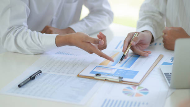 istock Two business teams discuss and analyze the graphs of project working together in office. 1206594127