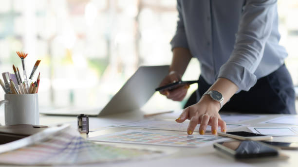 istock Cropped shot of young designer working on new application project while using smartphone in modern office room. 1206594761