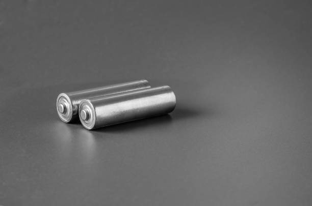 istock Two cylindrical batteries on a gray background. 1206594764