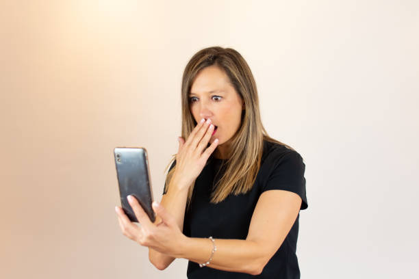 istock Young woman with mobile in hand surprised 1206594845