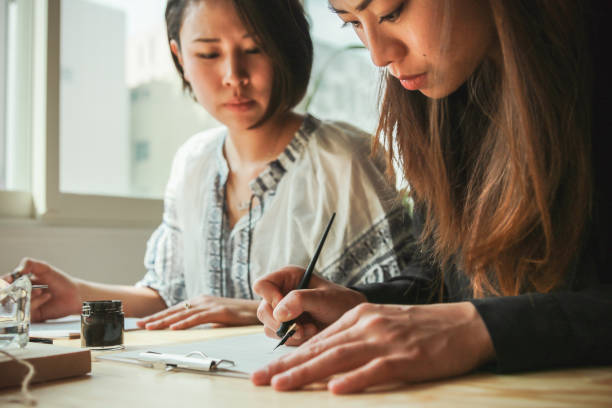 istock Two Asian women practice modern calligraphy - close up shot 1206595196