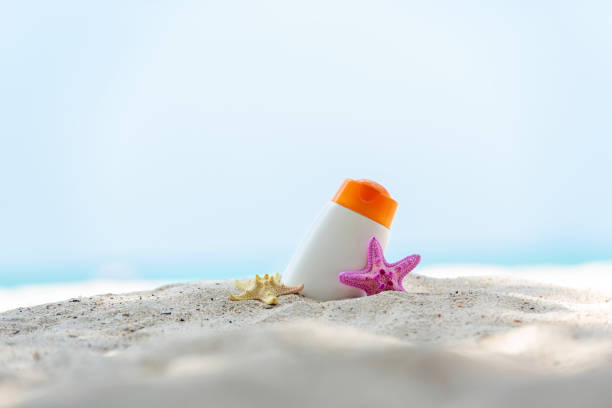 istock Protective sunscreen or sunblock and sunbath lotion in white plastic bottles with sandals on tropical beach background, summer accessories in holiday.  Summer Concept 1206596278