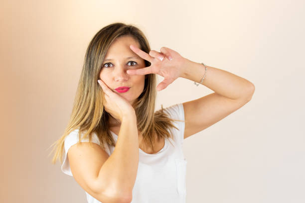 istock Young woman gesturing with fingers on her face 1206597165