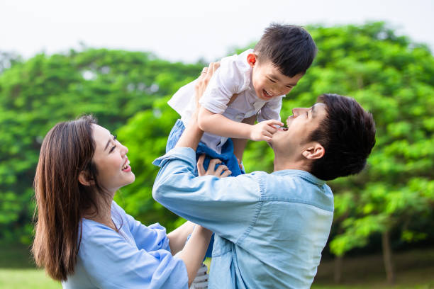 parents play with kid outdoor Father hold boy in his arm and parents play with kid outdoor korean ethnicity photos stock pictures, royalty-free photos & images