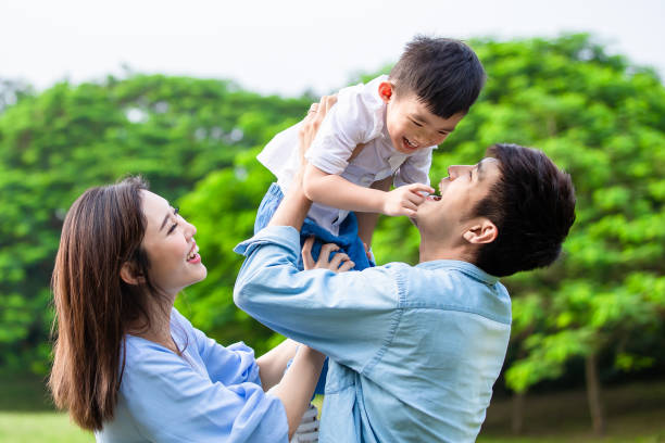 pais brincam com criança ao ar livre - japanese ethnicity family smiling happiness - fotografias e filmes do acervo