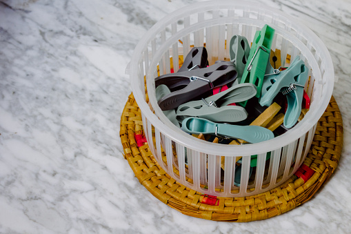 Colored clothespins to hang clothes in a basket