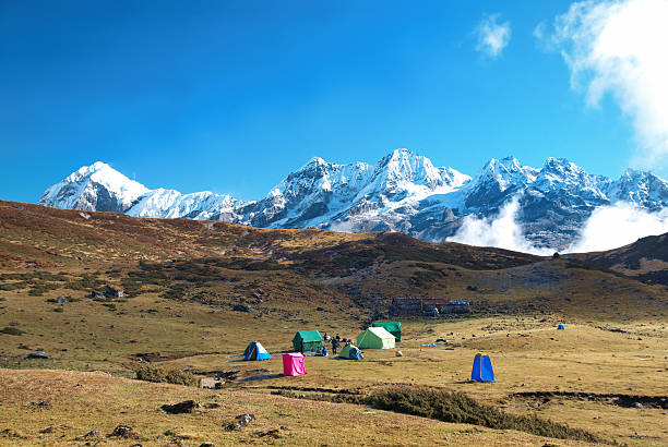 Tall mountains covered with snow and a campsite Top of High mountains, covered by snow. Kangchenjunga, India. kangchenjunga stock pictures, royalty-free photos & images