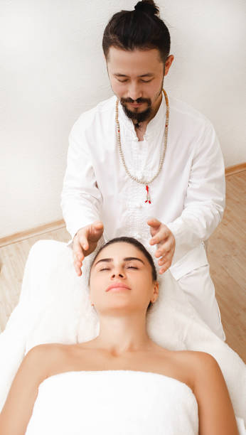 エネルギッシュなヘッドマッサージをしているカイロプラクター。レイキ療法を受ける女性。代替医療 - reiki alternative therapy massaging women ストックフォトと画像
