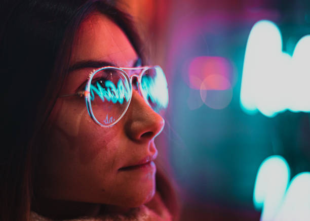 istock Neon light reflected on girl's glasses 1206601856