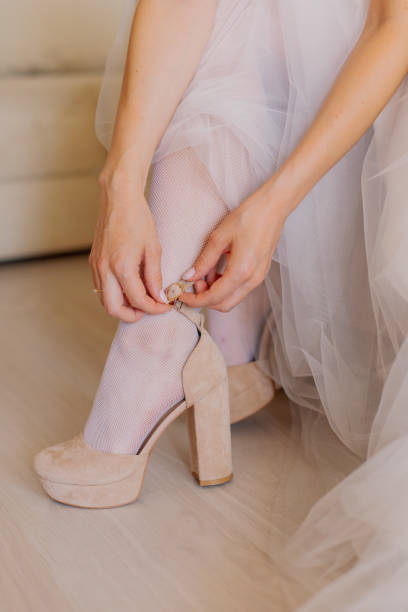 istock Young bride closes shoes on a happy wedding day 1206603832