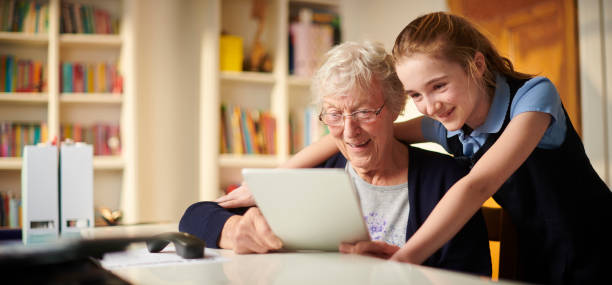помогая гран подключиться - senior adult technology child internet стоковые фото и изображения