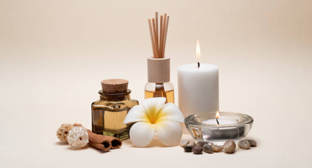 Beautiful spa composition with candles, frangipani flower, oil flasks and other decor elements. stock photo