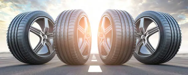 Photo of Four car wheel oln the highway with sky background.  Change a tires.