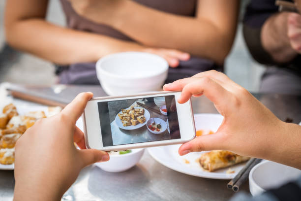 pov, woman taking smartphone photo of vietnamese meal at outdoor restaurant - asian cuisine food asian ethnicity vietnamese cuisine imagens e fotografias de stock