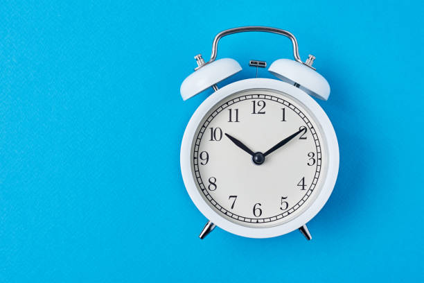 istock Vintage white alarm clock on the blue backround with copy space. Time concept 1206608018