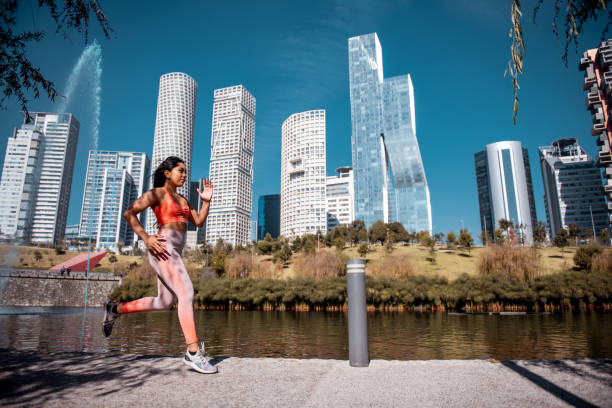 istock Young woman jogging by the river 1206608178