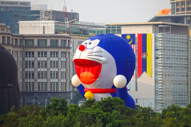 Putrajaya, Malaysia - March 18, 2011. A hot air balloon in a cartoon Doraemon design flying low in front of some buildings at the 3rd Putrajaya International Hot Air Balloon Festival.