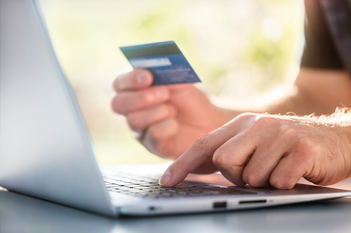 Man with credit card using a laptop computer for e-commerce internet shopping