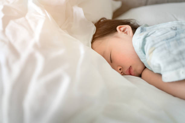 The child was sleeping on the bed. stock photo