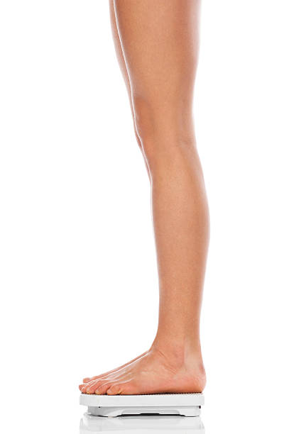 istock slender beautiful female feet standing on scales 120661713