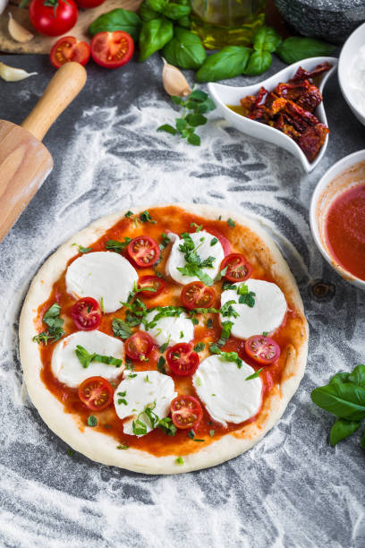 istock Prepering margherita pizza with mozzarella for baking 1206618075