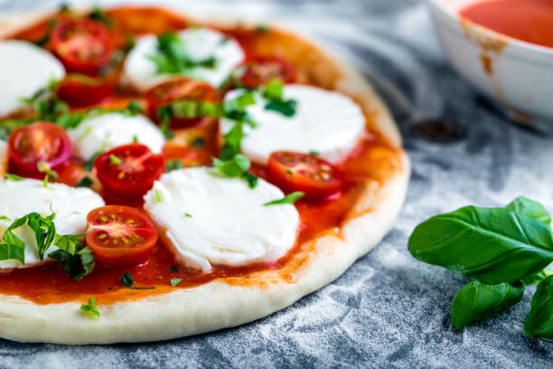 istock Prepering margherita pizza with mozzarella for baking 1206618133