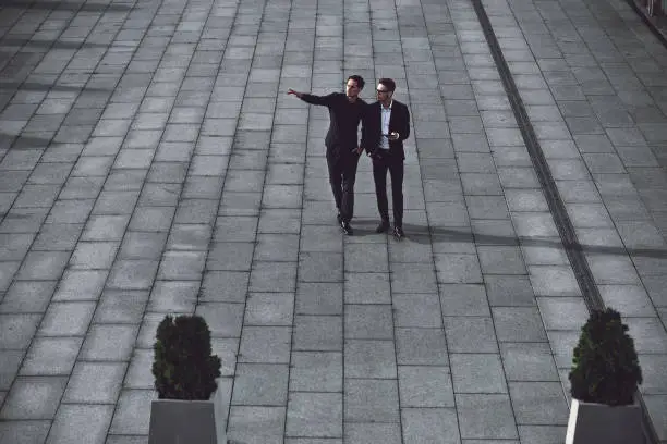 Photo of Two young businessmen walking in the street