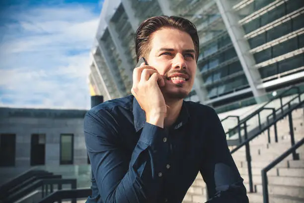 Photo of Successful caucasian businessman stand on stairs in modern city.