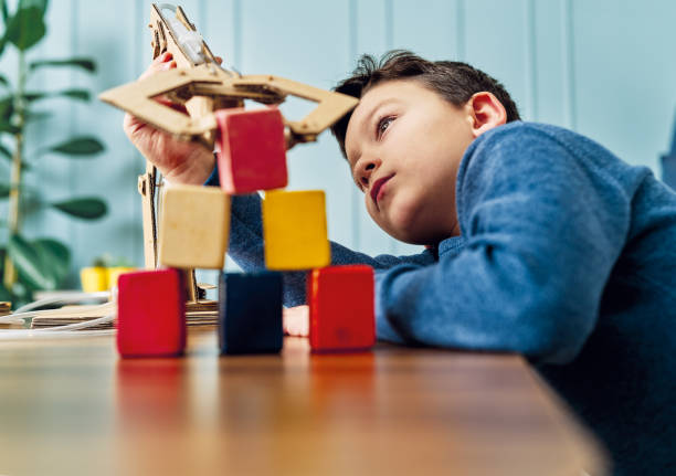 l’enfant de 6-7 ans a inventé un bras robotique avec le carton et la seringue. la robotique, c’est ses devoirs. il est un élève qui réussit à l’école primaire. - 6 7 years photos et images de collection