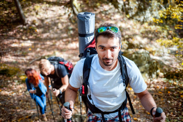 istock Handsome man trekking together with friends in a forest 1206627880