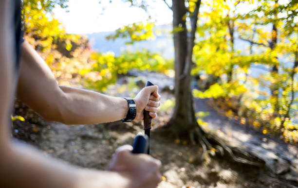 Man on trail holding trekking sticks