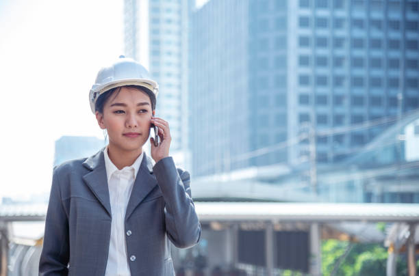 Construction engineer in Safety Suit Trust Team Holding White Yellow Safety hard hat Security Equipment on Construction Site. Hardhat Protect Head for Civil Construction Engineer. Engineering Concept