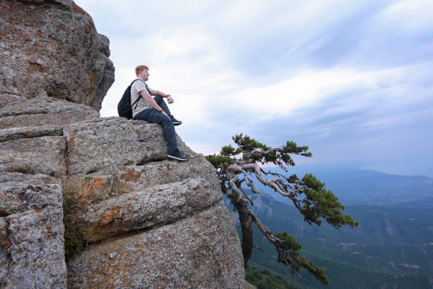istock Man sits on the cliff in Crimea 1206630871
