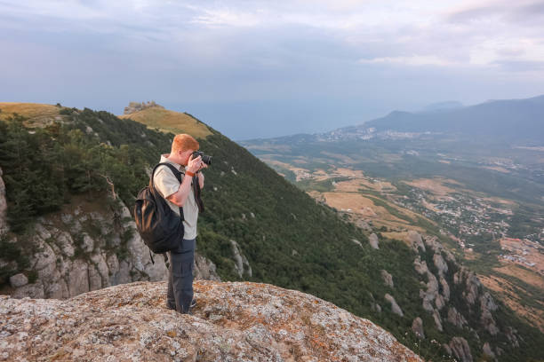 istock Photographer in mountains takes photos using reflex camera in Crimea 1206630885