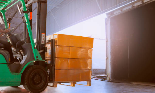 istock Forklift driver loading cargo pallet shipment with a truck container at dock warehouse 1206630947